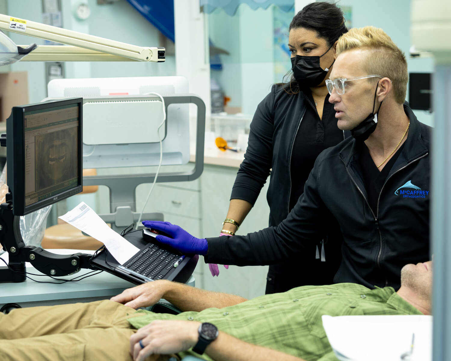 Orthodontist demonstrates digital scan technology to patient in modern dental clinic treatment room.
