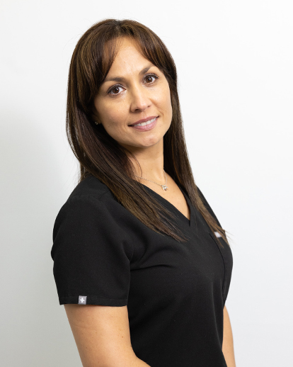 Professional headshot of woman in black scrubs against white background for dental practice.