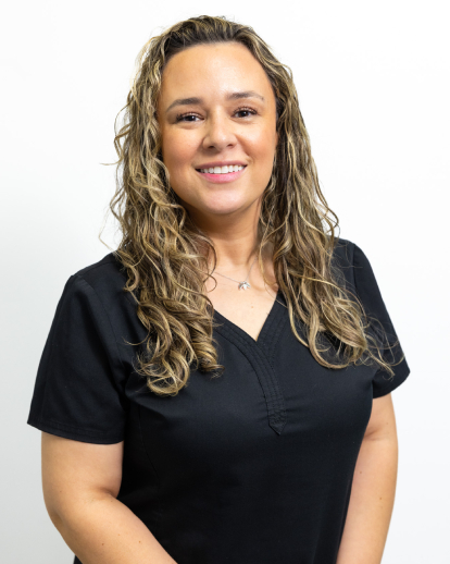 Professional headshot of smiling woman with long blonde hair wearing black v-neck shirt against white background.