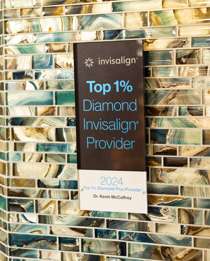 Invisalign Top 1% Diamond Provider award certificate displayed on brick wall background