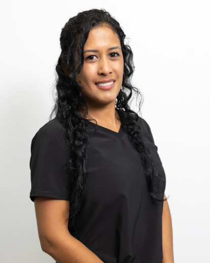 Woman with long braided black hair wearing black shirt against white background, professional headshot.