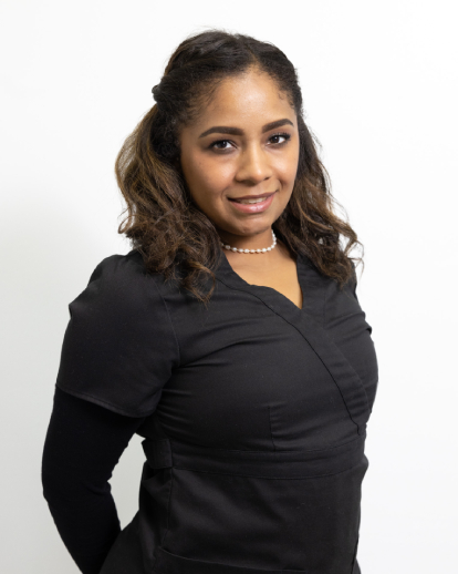 Professional portrait of woman in black long-sleeve top against white background for orthodontics practice.